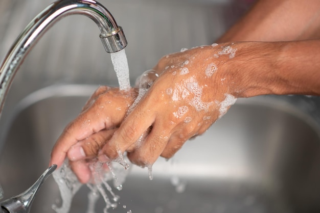 Le mani degli uomini stanno mostrando modi per lavarsi le mani con un gel detergente per prevenire le malattie infettive e prevenire il virus