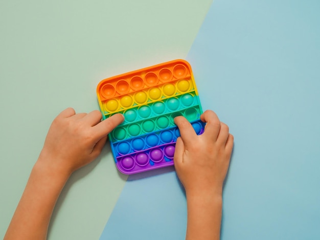 Le mani dei bambini giocano con la panoramica del giocattolo popit