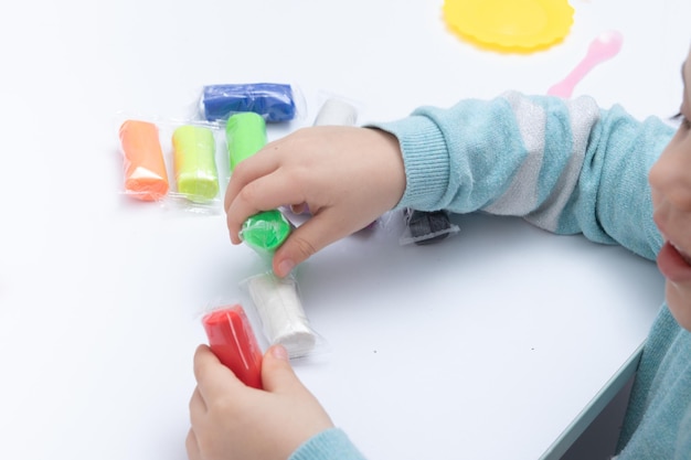 Le mani dei bambini giocano con la pasta per la creatività dei bambini. Gioco da tavolo per lo sviluppo della motricità fine.