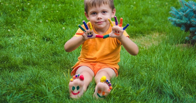 Le mani dei bambini nei colori dell'estate un sorriso sul palmo del ragazzo