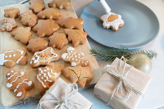 Le mani dei bambini preparano i biscotti di panpepato di Capodanno su un tavolo di legno. Fare i biscotti con un tagliabiscotti. Anno nuovo e concetto di Natale.