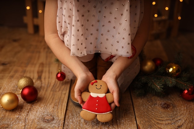 Le mani dei bambini tengono un pan di zenzero di Capodanno