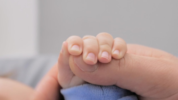 Le mani dei genitori che tengono i neonati le dita ravvicinate dei padri che tengono la mano del neonato amore