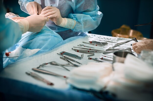 Le mani del chirurgo tengono in mano uno strumento operativo in sala operatoria.
