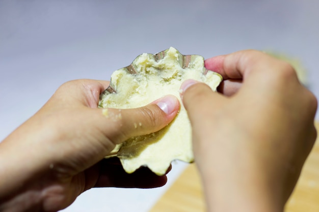 Le mani del cuoco formano un impasto per tortine