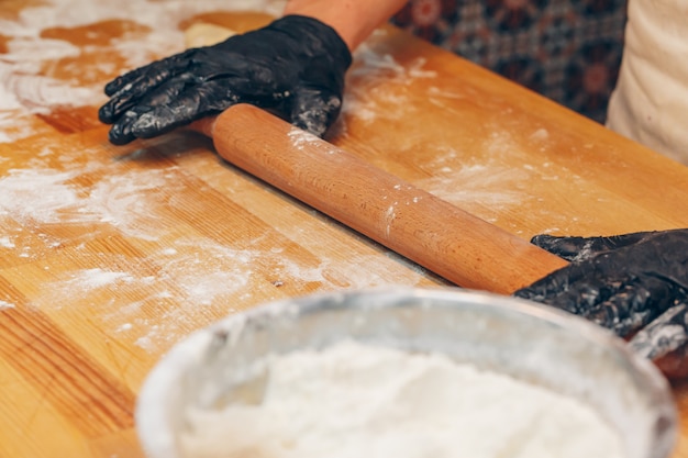 Le mani del cuoco unico in guanti neri preparano la fine della pasta in su