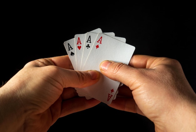 Le mani del giocatore tengono le carte da gioco con una combinazione vincente di quattro o quattro