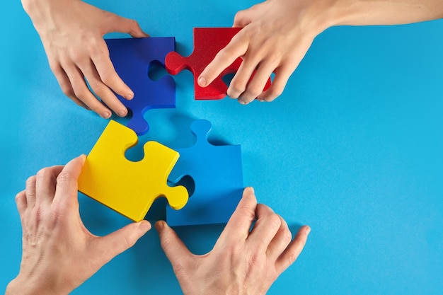 Le mani del padre e del figlio autistico che tengono il puzzle formano la giornata mondiale della consapevolezza dell'autismo