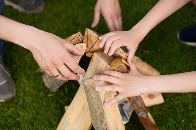 Le mani del padre e del figlio tengono la legna da ardere per il fuoco