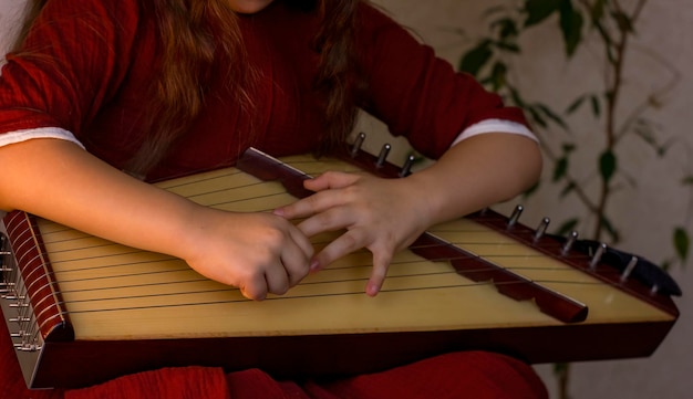 Le mani del primo piano della bambina stanno giocando il gusli