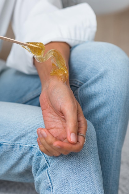 Le mani dell'estetista tengono la pasta di zucchero liquida