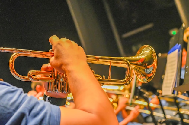 Le mani dell'uomo che suonano una tromba nell'orchestra