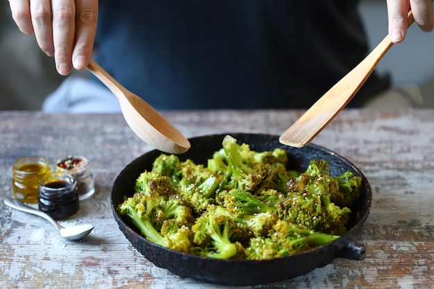 Le mani dell'uomo cucinano i broccoli.