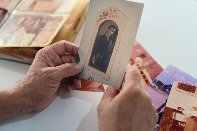 Le mani dell'uomo più anziano che guardano la vecchia fotografia