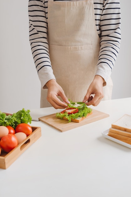 Le mani dell'uomo preparano il panino a casa.