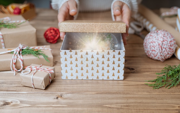 Le mani della donna aprono il regalo di Natale