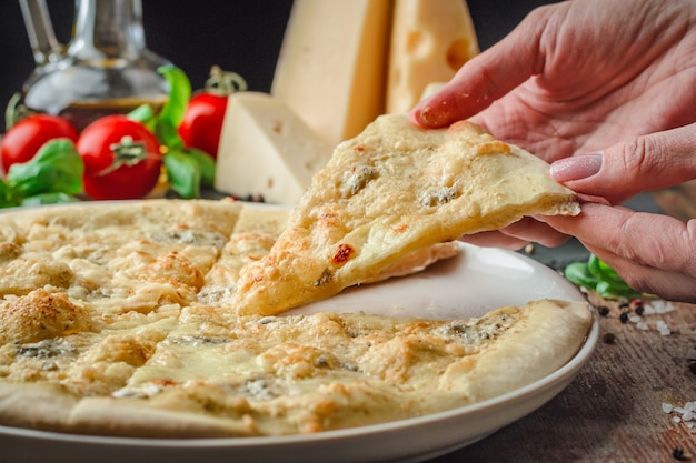 Le mani della donna che prendono fette di pizza