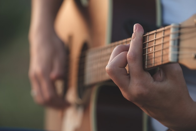 Le mani della donna che suonano la chitarra acustica Strumento musicale per il concetto di passione ricreativa o hobby