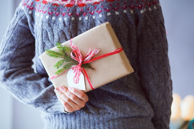 Le mani della donna che tengono il contenitore di regalo di natale Natale