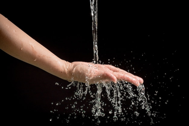 Le mani della donna con spruzzi d&#39;acqua