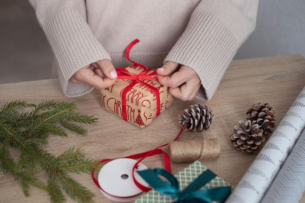 Le mani della donna incartano il regalo di Natale