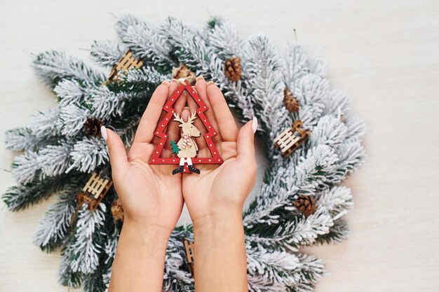 Le mani della donna tengono i giocattoli Vista dall'alto della trama festiva di Natale con decorazioni di Capodanno