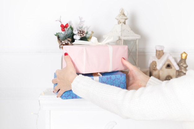 Le mani della donna tengono il contenitore di regalo decorato natale o del nuovo anno
