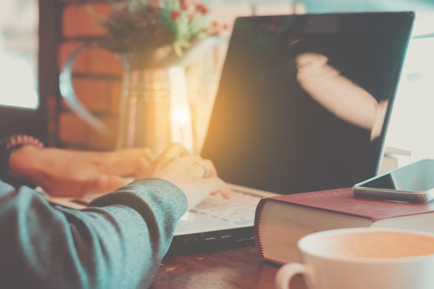 le mani della donna usando il funzionamento del computer portatile