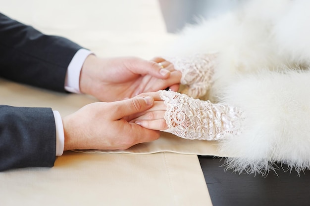 Le mani della sposa e dello sposo nel giorno del loro matrimonio amano