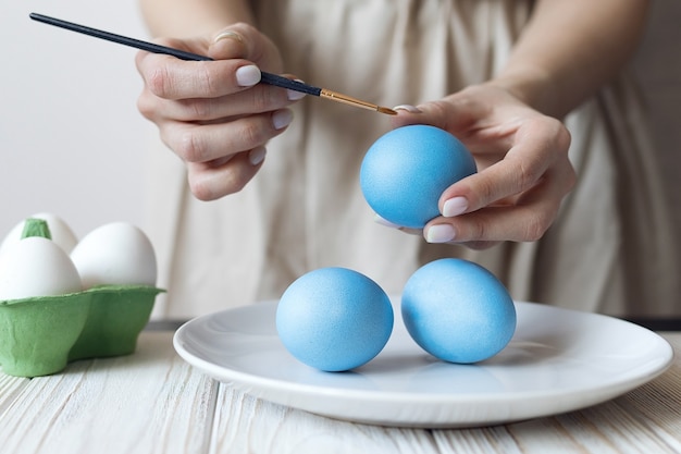 Le mani delle donne decorano le uova sode per la pasqua. Foto di alta qualità