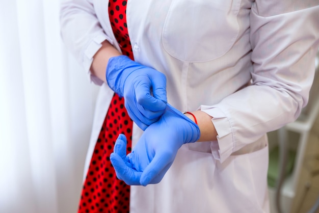 Le mani delle donne in guanti di gomma tengono la siringa con la medicina