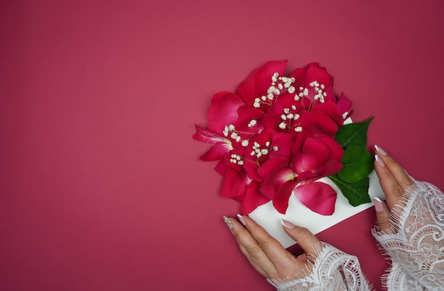 Le mani delle donne tengono una busta con petali di rosa
