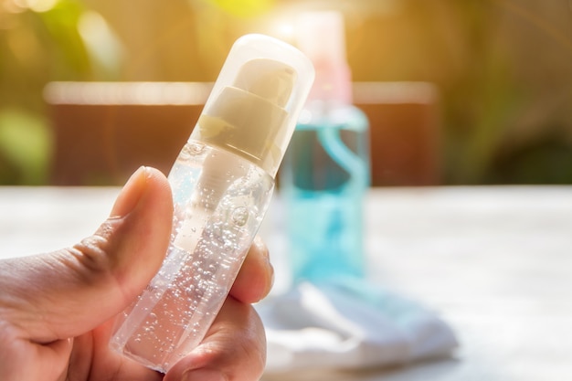 Le mani delle persone vengono trattenute dalla bottiglia della pompa applicando gel di alcool o sapone antibatterico per rendere le mani pulite e eliminare germi, batteri