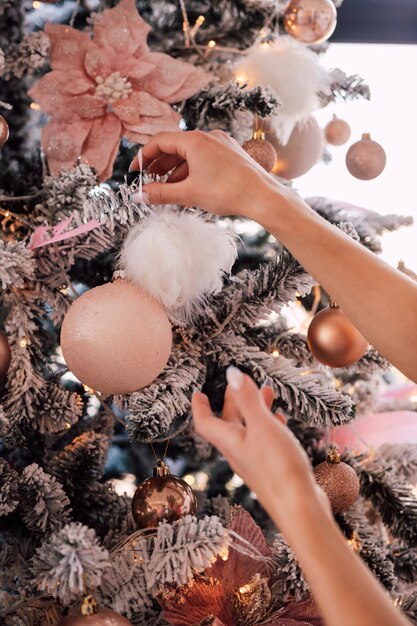 Le mani delle ragazze decorano l'albero di Natale