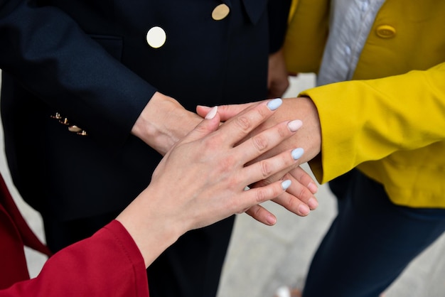 Le mani delle ragazze una sopra l'altra Idea dell'unione di amicizia d'affari