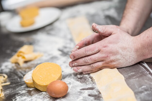 Le mani dello chef preparano ravioli di pasta ripiena di cibo italiano.