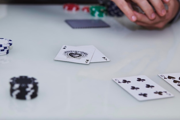 Le mani di Man39s mescolano le carte 2 assi sul tavolo in un gioco di poker con le chips sul tavolo Godersi il momento disintossicazione digitale con gli amici Fotografia di stile di vita Momento schietto Messa a fuoco selettiva