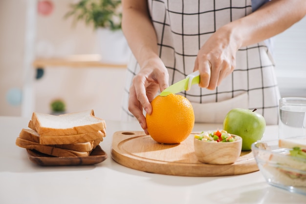 Le mani di una donna stanno preparando il pranzo a scuola. È più interessante per i bambini.