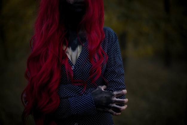 Le mani e la bocca della ragazza sono imbrattate, dipinte di nero con vernice. Primo piano della mano della ragazza. Dai capelli rossi