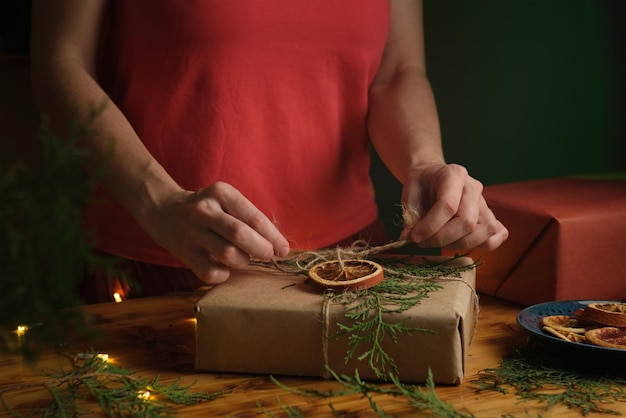 Le mani femminili decorano il regalo di Natale