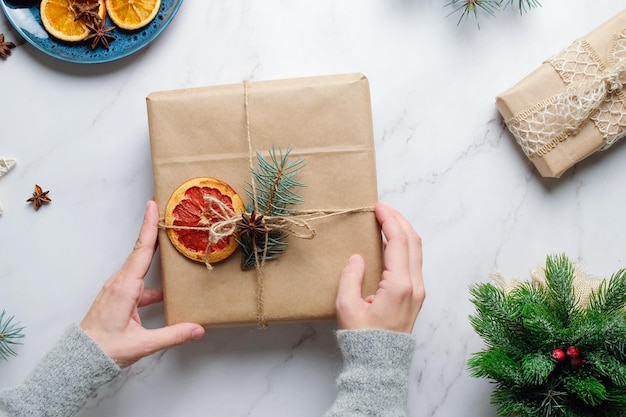 Le mani femminili decorano il regalo di Natale