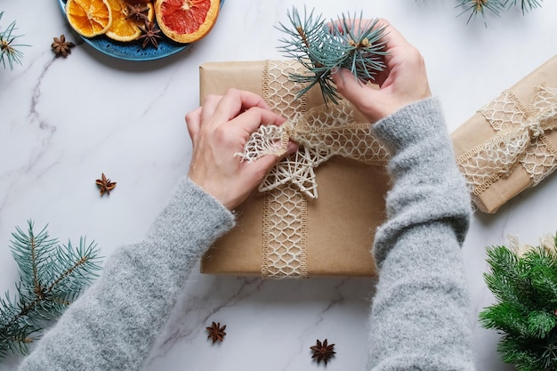 Le mani femminili decorano il regalo di Natale