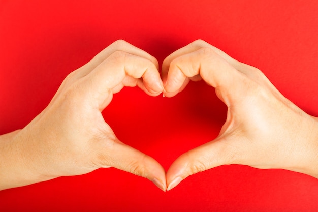 Le mani femminili fanno il cuore delle mani il giorno di San Valentino.