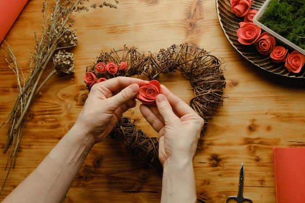 Le mani femminili fanno la decorazione fai-da-te di San Valentino