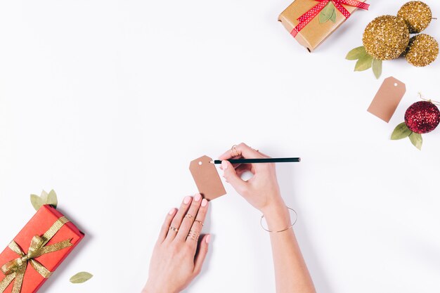 Le mani femminili stanno preparando decorazioni natalizie