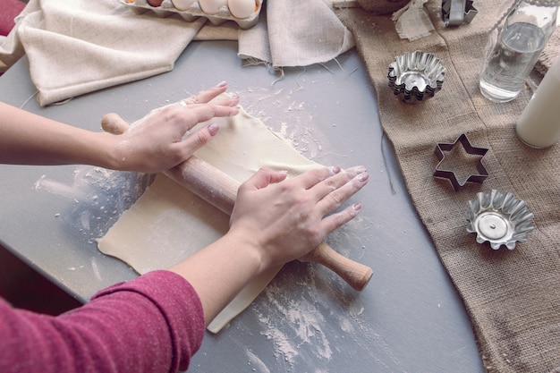 Le mani femminili stendono la pasta