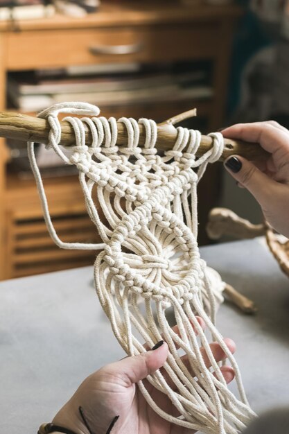 Le mani femminili tessono il macramè l'officina domestica Stile di vita Boho Concetto di hobby per hobby Messa a fuoco selettiva