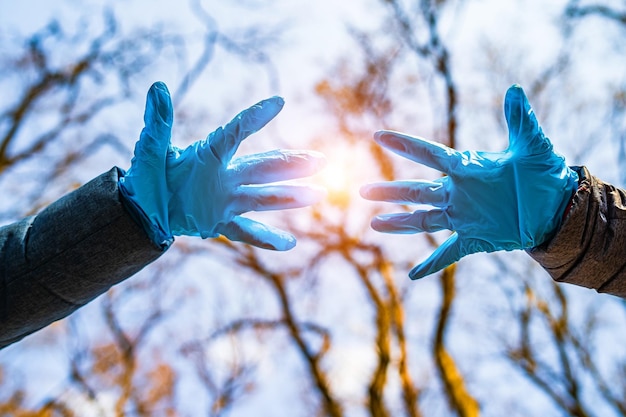 Le mani in guanti medici blu per strada evitano la diffusione del coronavirus Pandemia Covid19 Ferma il coronavirus