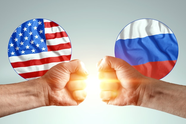Le mani maschili mostrano i loro pugni sullo sfondo delle bandiere dell'America e della Russia.