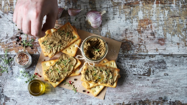 Le mani maschili spalmano la pasta fatta in casa sul cracker.